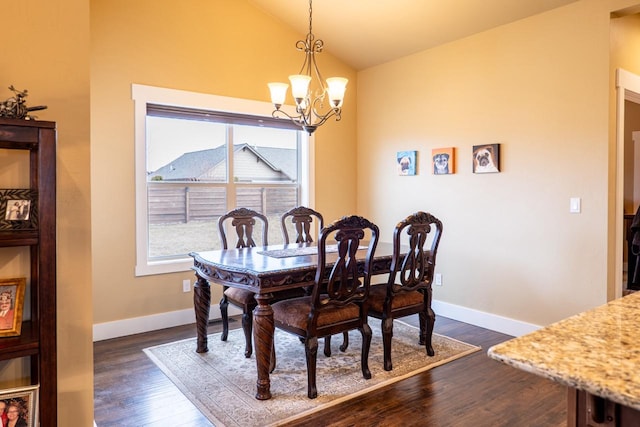 dining area with lofted ceiling, dark wood finished floors, a notable chandelier, and baseboards