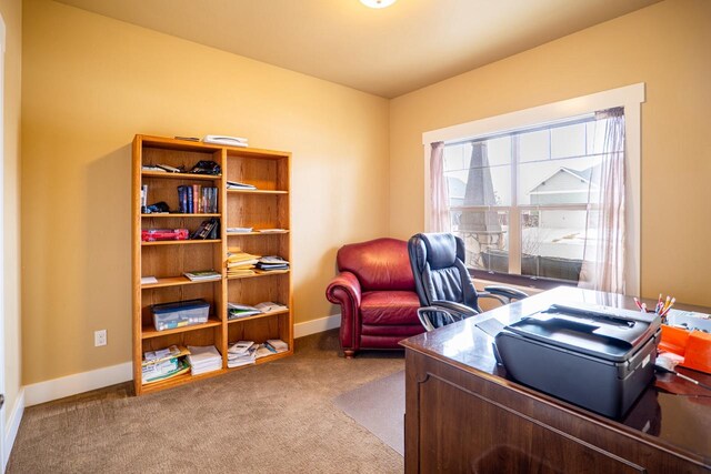 carpeted home office featuring baseboards