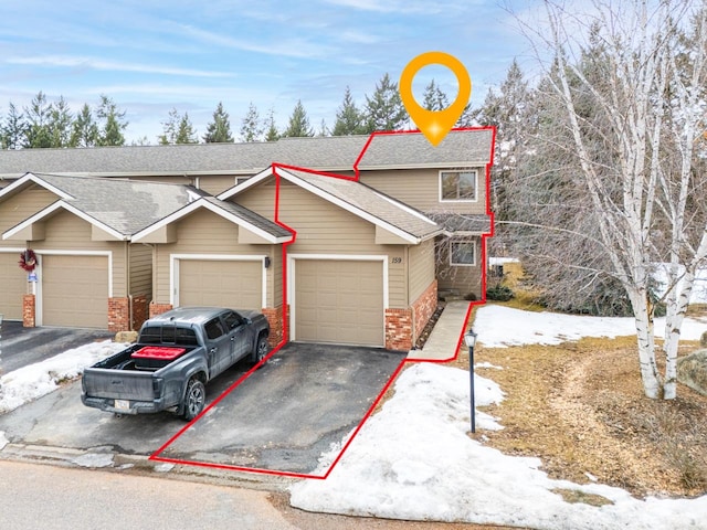 view of property with a garage, brick siding, a shingled roof, and aphalt driveway