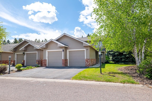 159 Fairway Blvd, Kalispell, MT 59901 - view of front facade featuring brick siding, asphalt driveway, an attached garage, and a front lawn