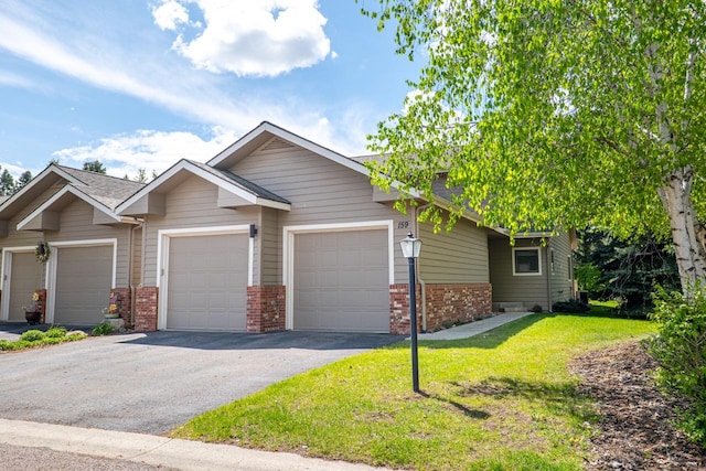 159 Fairway Blvd, Kalispell, MT 59901 - view of front of home featuring brick siding, asphalt driveway, an attached garage, and a front yard