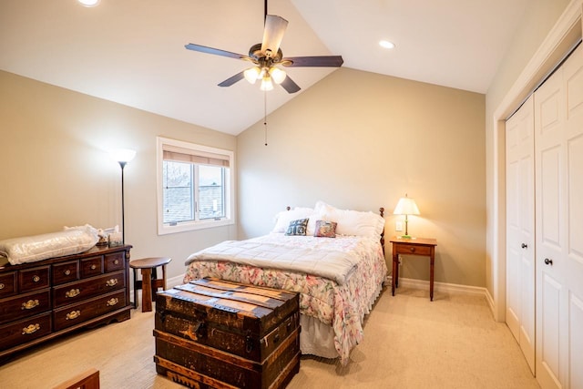 bedroom with lofted ceiling, baseboards, a closet, and light colored carpet