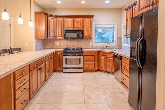 159 Fairway Blvd, Kalispell, MT 59901 - kitchen with black appliances, a sink, recessed lighting, brown cabinetry, and tasteful backsplash