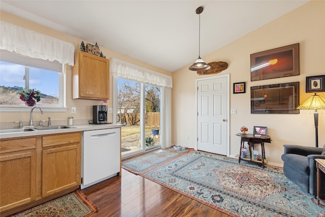 kitchen featuring lofted ceiling, light countertops, white dishwasher, a sink, and plenty of natural light