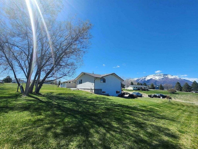 view of home's exterior featuring a mountain view and a lawn