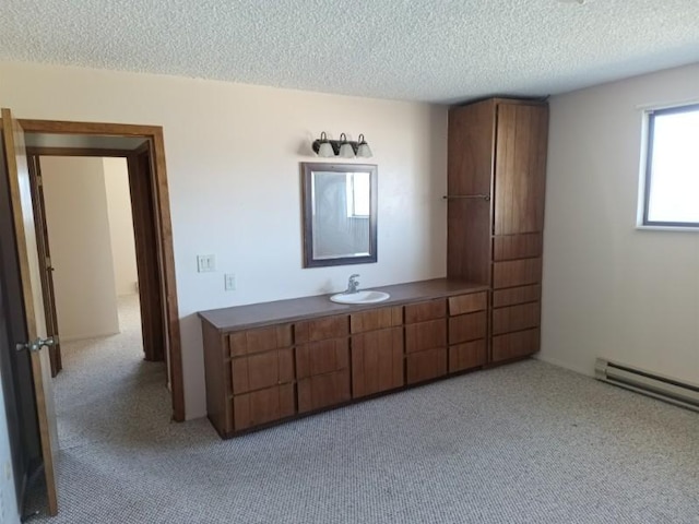 bathroom with a textured ceiling, a baseboard radiator, carpet flooring, and vanity