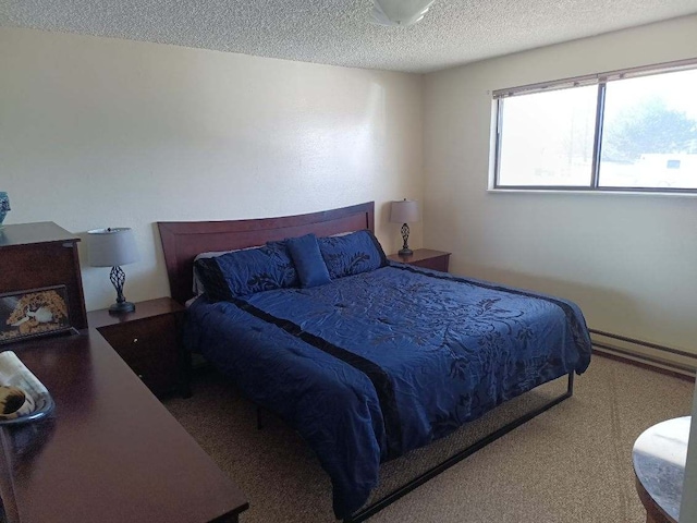 bedroom featuring a baseboard heating unit and a textured ceiling