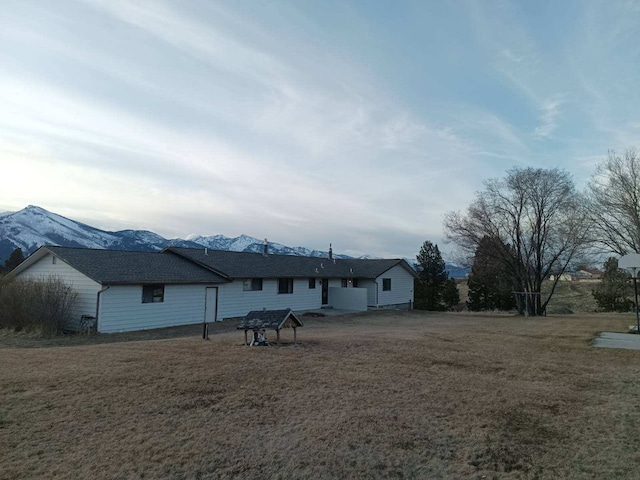 back of house with a yard and a mountain view