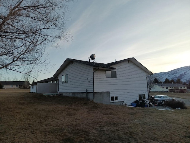 view of side of property with a yard and a mountain view