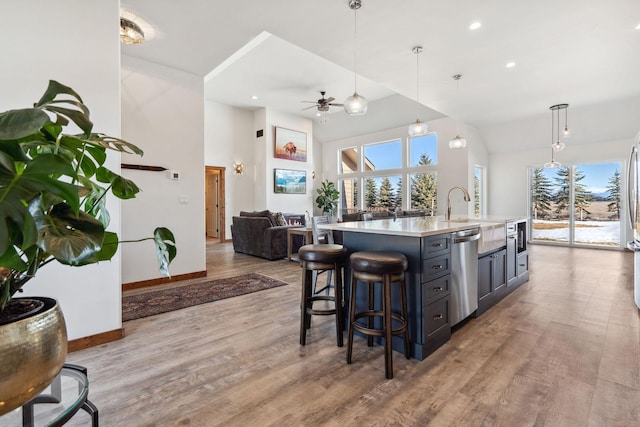 kitchen featuring light wood-style floors, open floor plan, light countertops, and dishwasher