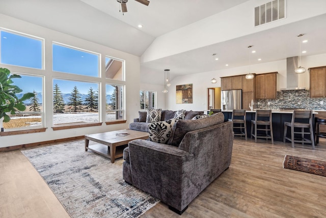 living room with ceiling fan, visible vents, wood finished floors, and recessed lighting