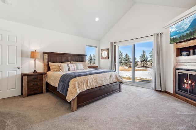 bedroom with access to exterior, a lit fireplace, high vaulted ceiling, and carpet flooring