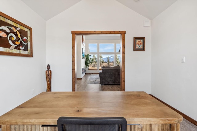 dining area featuring vaulted ceiling, baseboards, and wood finished floors