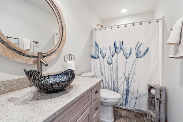 full bathroom featuring curtained shower, recessed lighting, toilet, vanity, and wood finished floors