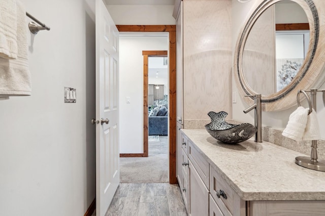 bathroom with vanity, baseboards, and wood finished floors