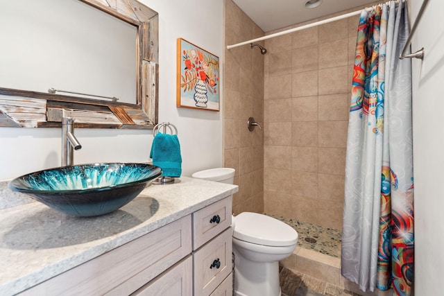 full bath with toilet, a tile shower, and vanity