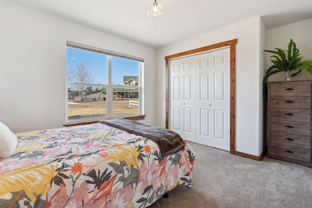 carpeted bedroom featuring a closet and baseboards