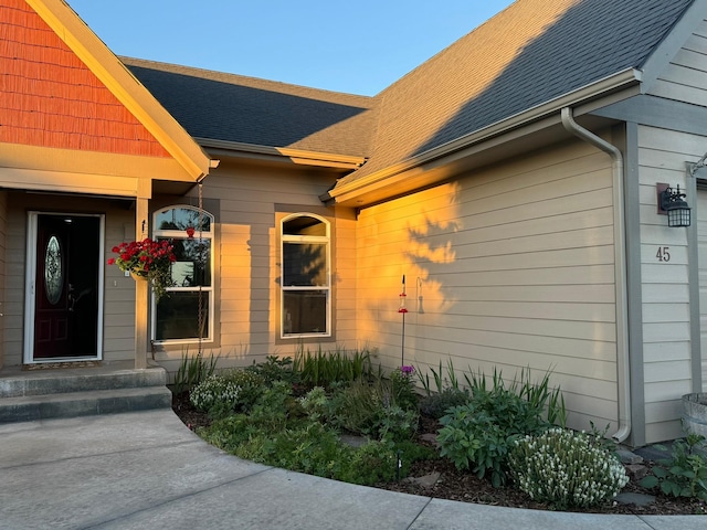 entrance to property with a shingled roof