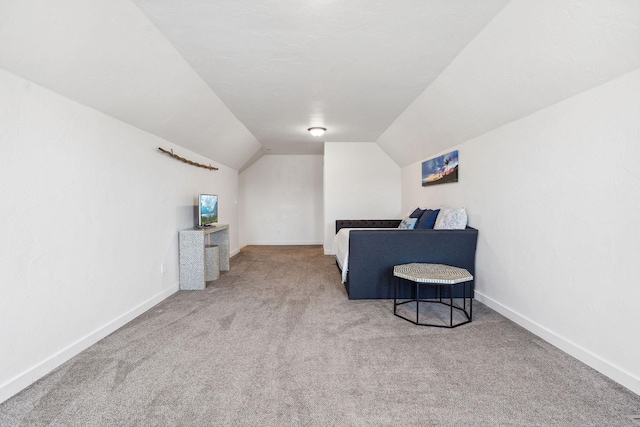 sitting room featuring vaulted ceiling, carpet, and baseboards