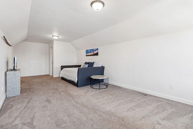 bedroom with lofted ceiling, baseboards, visible vents, and carpet