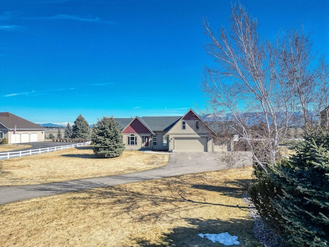 view of front of house featuring an attached garage, driveway, and fence