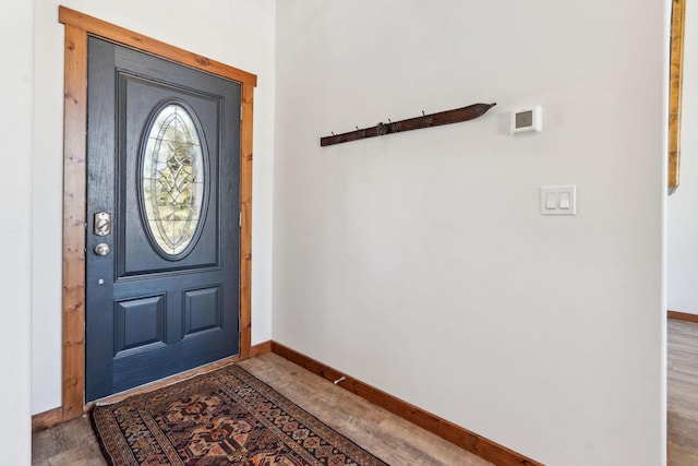 foyer featuring baseboards and wood finished floors