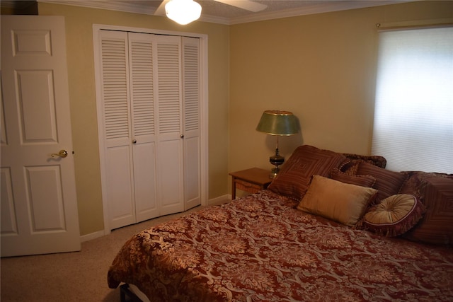bedroom featuring carpet flooring, a ceiling fan, baseboards, ornamental molding, and a closet