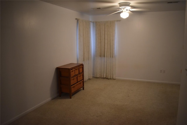 unfurnished bedroom featuring a ceiling fan, baseboards, visible vents, and light carpet