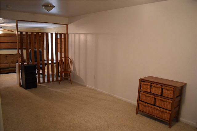 interior space with carpet floors, a ceiling fan, and baseboards