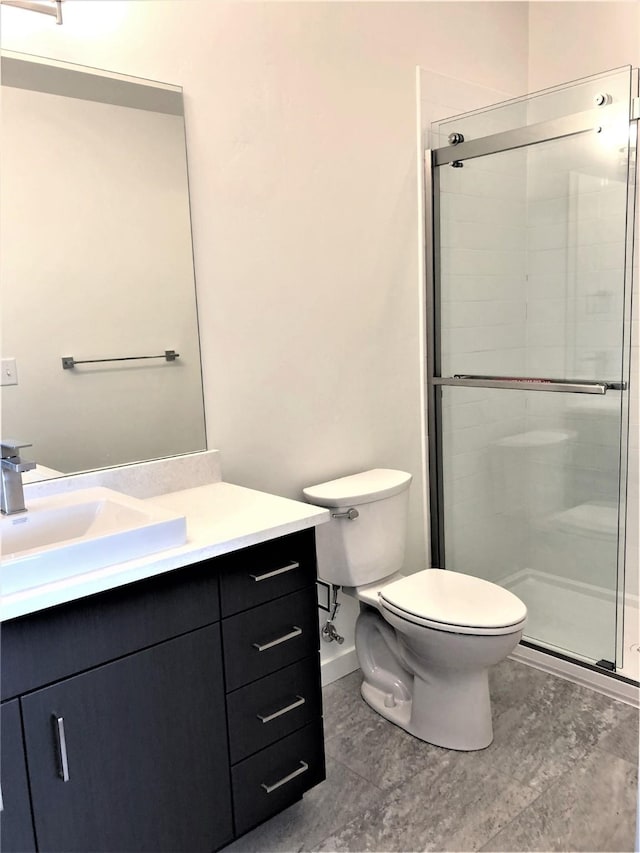 full bathroom featuring a stall shower, vanity, and toilet