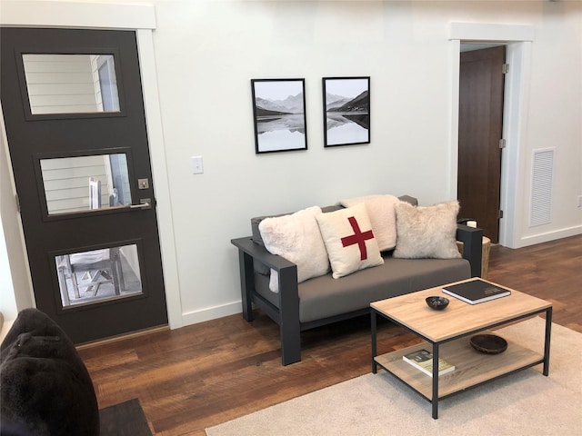 living room featuring wood finished floors, visible vents, and baseboards