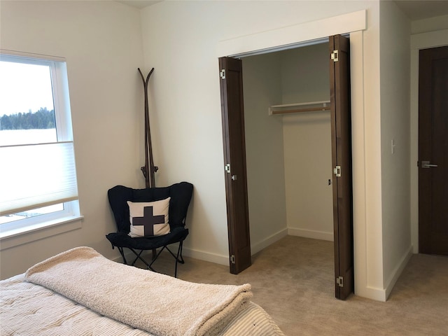 bedroom featuring light carpet, multiple windows, and baseboards