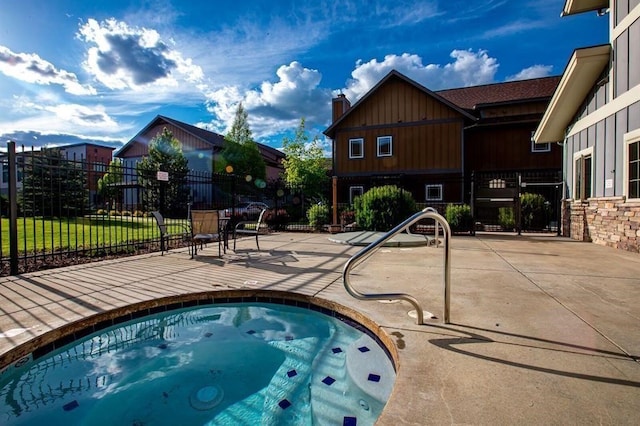 view of swimming pool with an in ground hot tub, a patio area, and fence