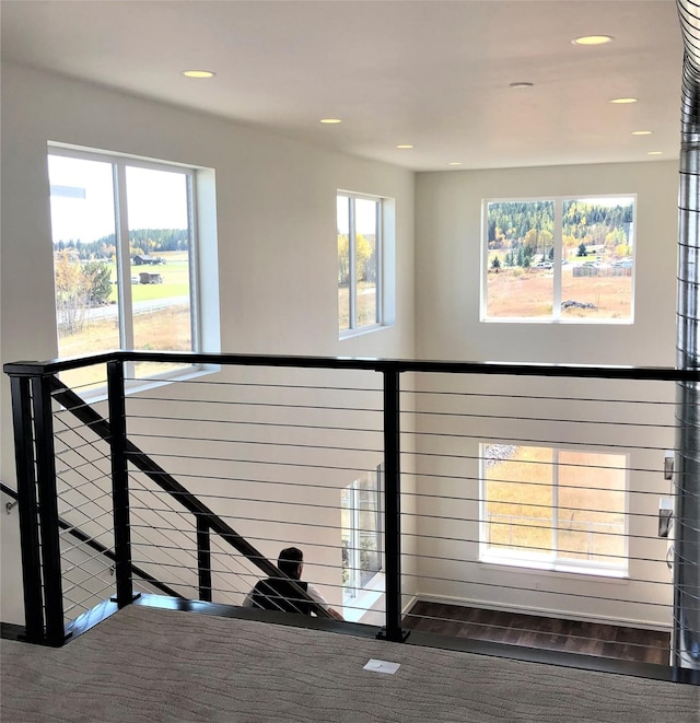 stairs featuring wood finished floors and recessed lighting