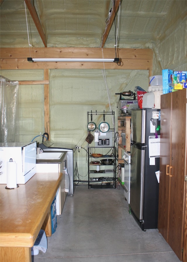 below grade area featuring freestanding refrigerator