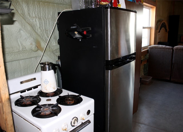 kitchen featuring freestanding refrigerator and white gas range