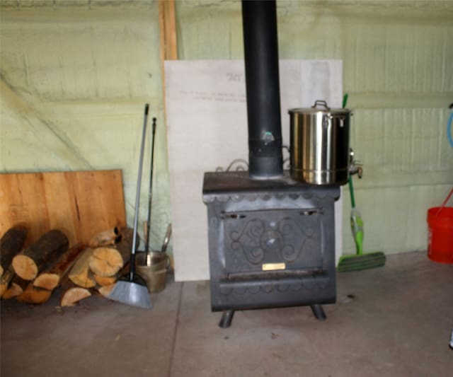 details with a wood stove and concrete floors