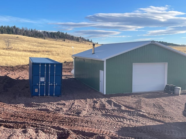 view of outbuilding with dirt driveway and an outdoor structure