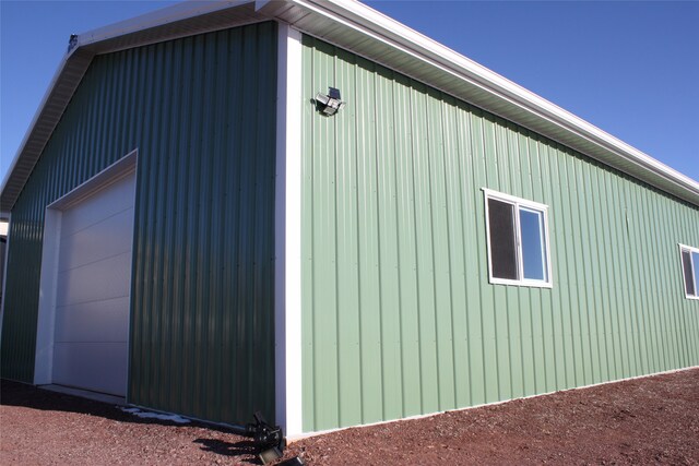 view of side of property featuring a garage and an outbuilding