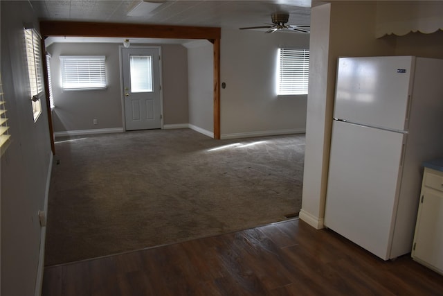 carpeted entrance foyer featuring ceiling fan, baseboards, wood finished floors, and beamed ceiling