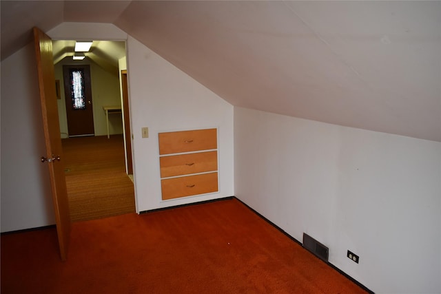 additional living space with carpet floors, lofted ceiling, and visible vents