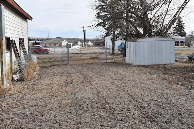 view of yard featuring a shed, fence, and an outdoor structure