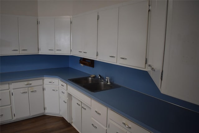 kitchen featuring dark wood-style flooring, white cabinetry, and a sink