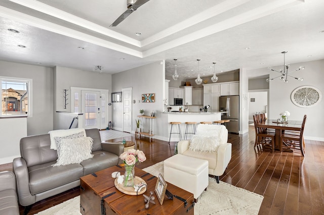1100 Choteau Ave NE, Great Falls, MT 59404 - living area featuring dark wood-style flooring, a chandelier, crown molding, a ceiling fan, and a raised ceiling