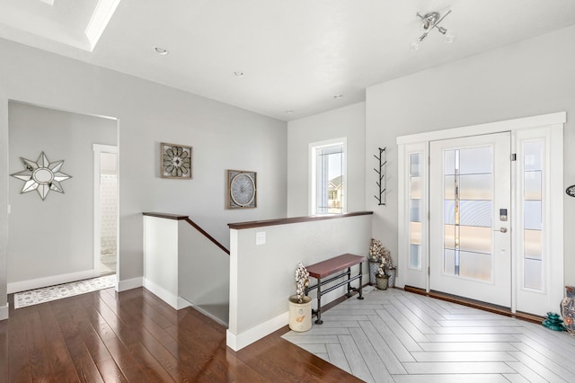 foyer with recessed lighting, parquet floors, and baseboards