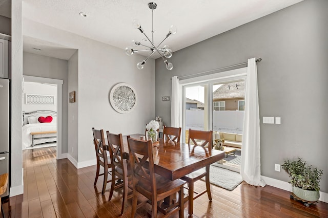 dining room with a notable chandelier, baseboards, and dark wood-style flooring