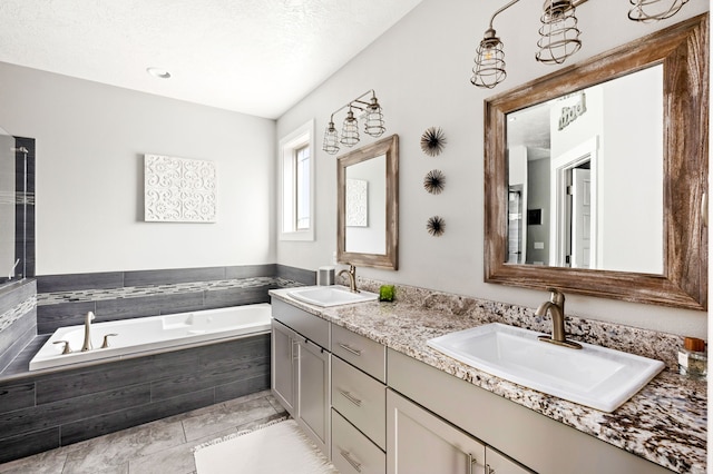 bathroom featuring a garden tub, double vanity, and a sink