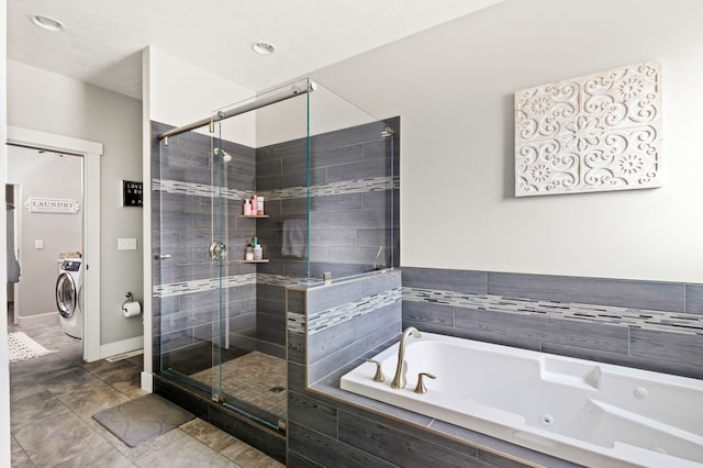 full bath with tile patterned flooring, a stall shower, a whirlpool tub, and washing machine and clothes dryer