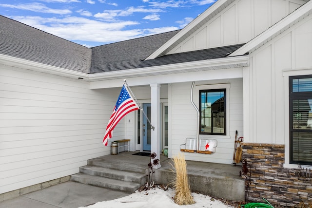 property entrance featuring board and batten siding and roof with shingles