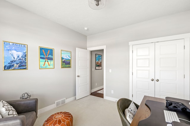 carpeted office with visible vents and baseboards